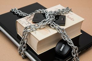 Computer and book wrapped in chains